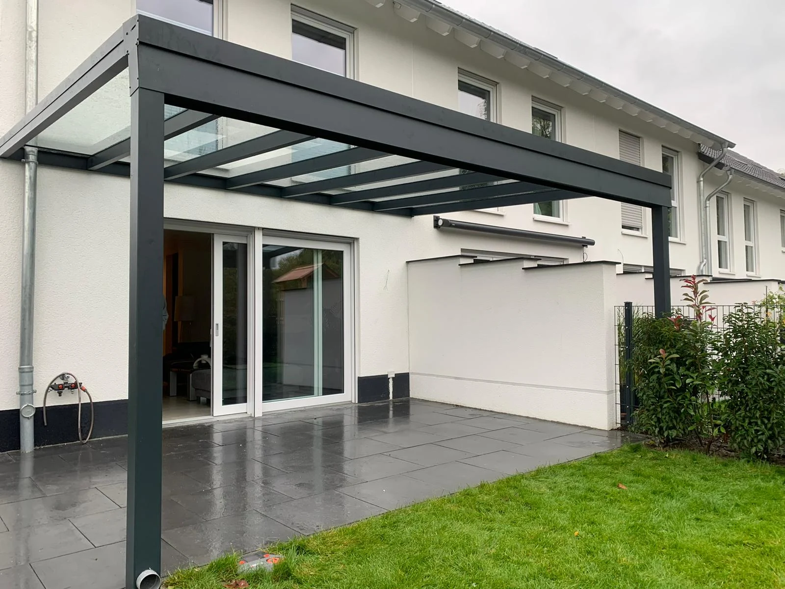 Terrassendach an einem hellen Wohnhaus